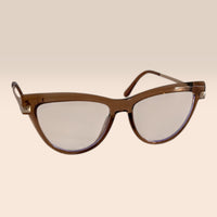Cat-eye sunglasses with brown frame and clear lenses on a beige background